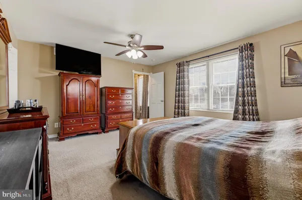 a spacious bedroom with a bed and flat screen tv
