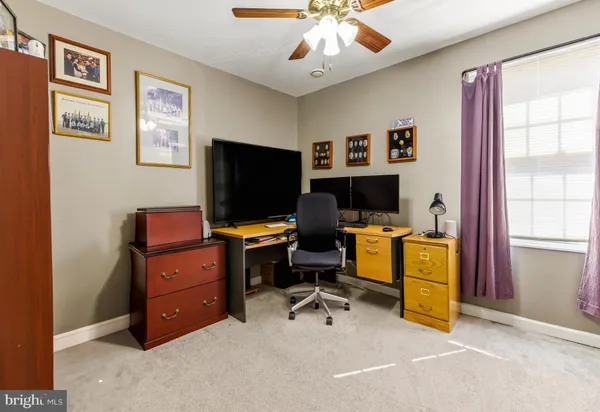 a view of a workspace with furniture and a window