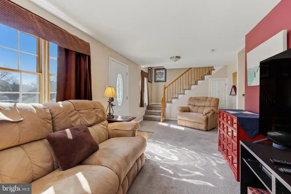 a living room with furniture a flat screen tv and a window