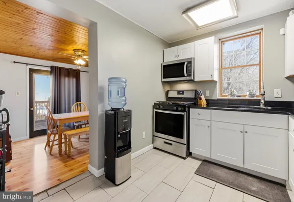 a kitchen with stainless steel appliances kitchen island granite countertop a stove a sink and a microwave
