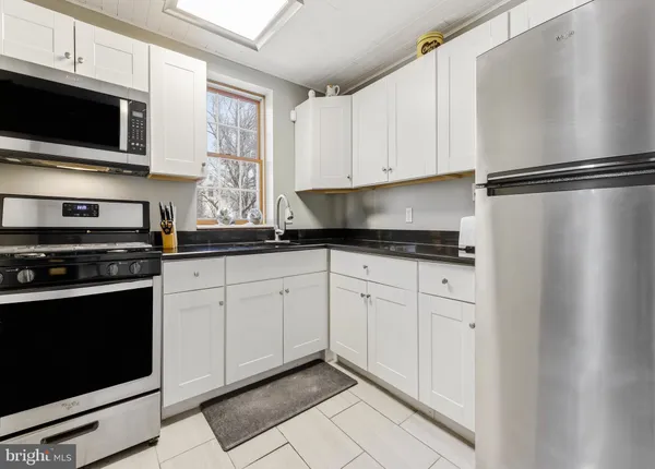 a kitchen with granite countertop cabinets stainless steel appliances and a window