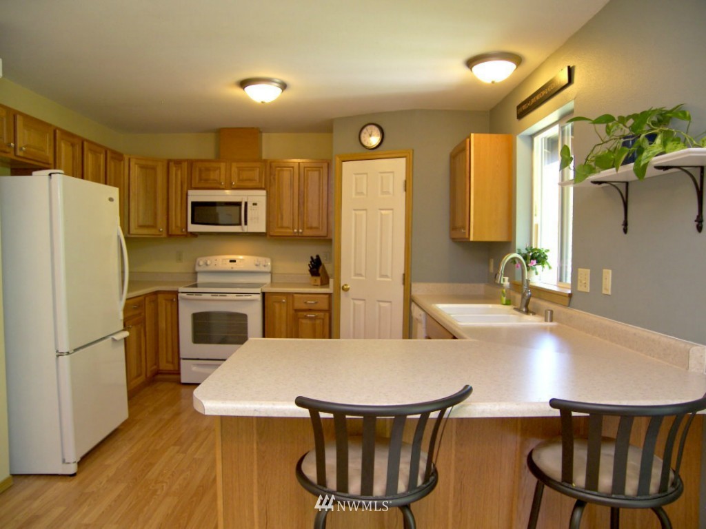 1496 Roma Road Bellingham, WA 98226 - Photo 3 of 14 a kitchen with a refrigerator a stove a sink dishwasher with a dining table and chairs
