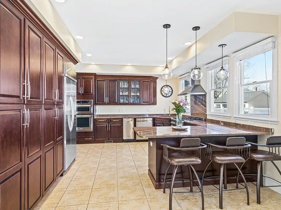 58 Spiers Road Newton, MA 02459 - Photo 2 of 21 a kitchen with stainless steel appliances kitchen island granite countertop a table chairs and a refrigerator