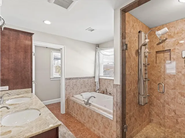 a bathroom with a granite countertop sink a mirror and a bathtub