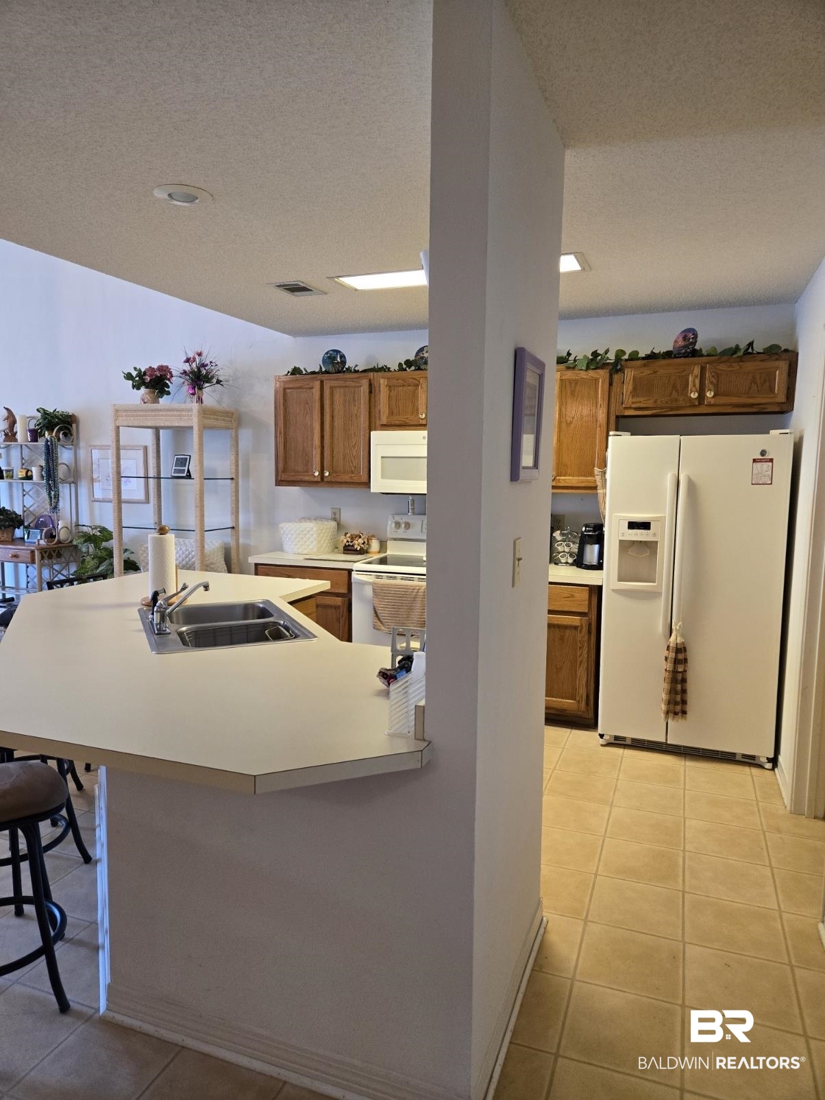 3200 Loop Road, Unit 87 Orange Beach, AL 36561 - Photo 20 of 46 Kitchen featuring light tile patterned flooring, white appliances, sink, and a textured ceiling