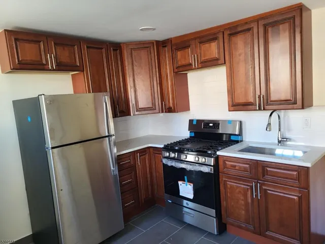 a kitchen with stainless steel appliances granite countertop a stove a refrigerator a sink and a cabinets