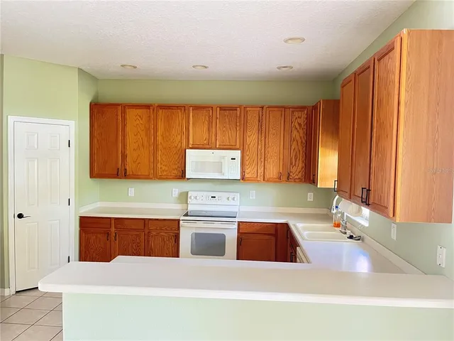 a kitchen with a sink a refrigerator and cabinets