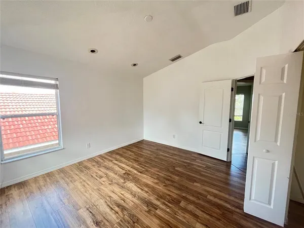 a view of a livingroom with wooden floor and a window