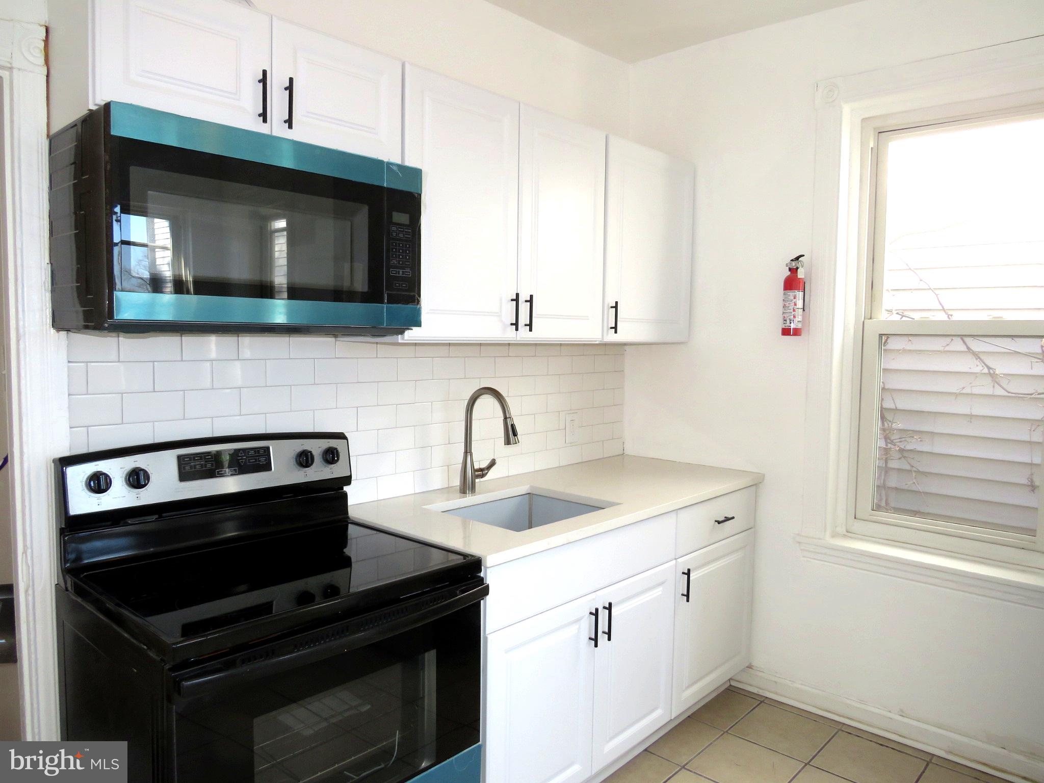 a kitchen with a sink stove and microwave
