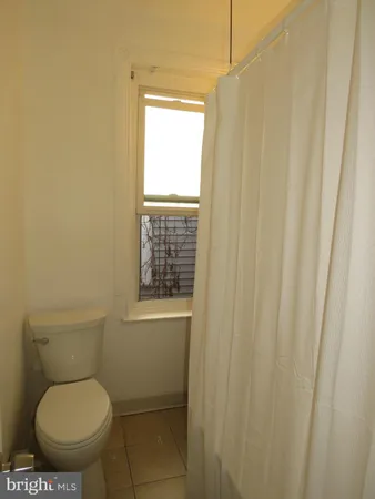 a white toilet sitting next to a window