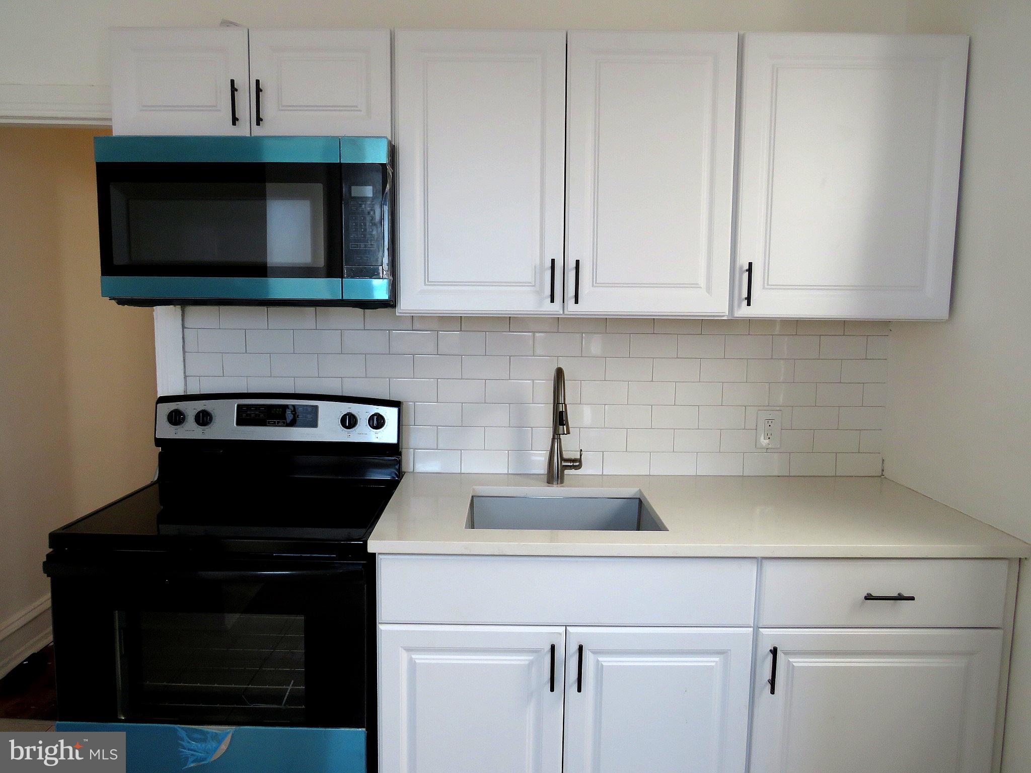 356 East Walnut Lane, Unit 2 Philadelphia, PA 19144 - Photo 2 of 18 a kitchen with stainless steel appliances granite countertop a sink stove and microwave