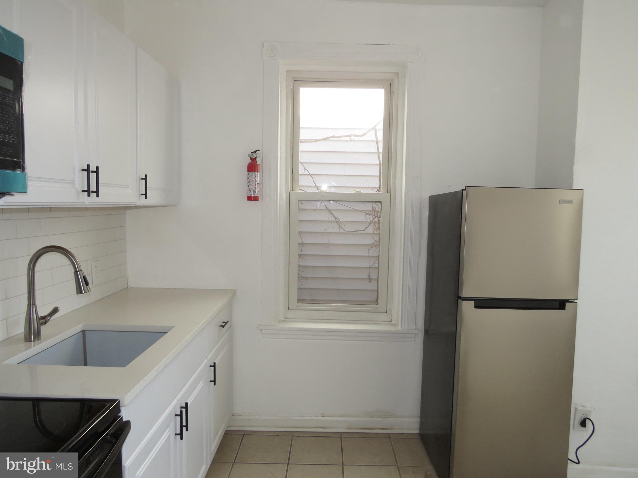 356 East Walnut Lane, Unit 2 Philadelphia, PA 19144 - Photo 5 of 18 a kitchen with a refrigerator and cabinets