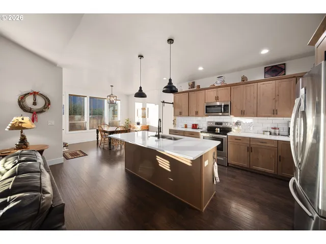 a kitchen with kitchen island granite countertop a sink stainless steel appliances and cabinets
