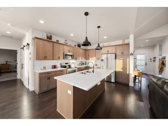a kitchen with stainless steel appliances kitchen island a sink cabinets and wooden floor