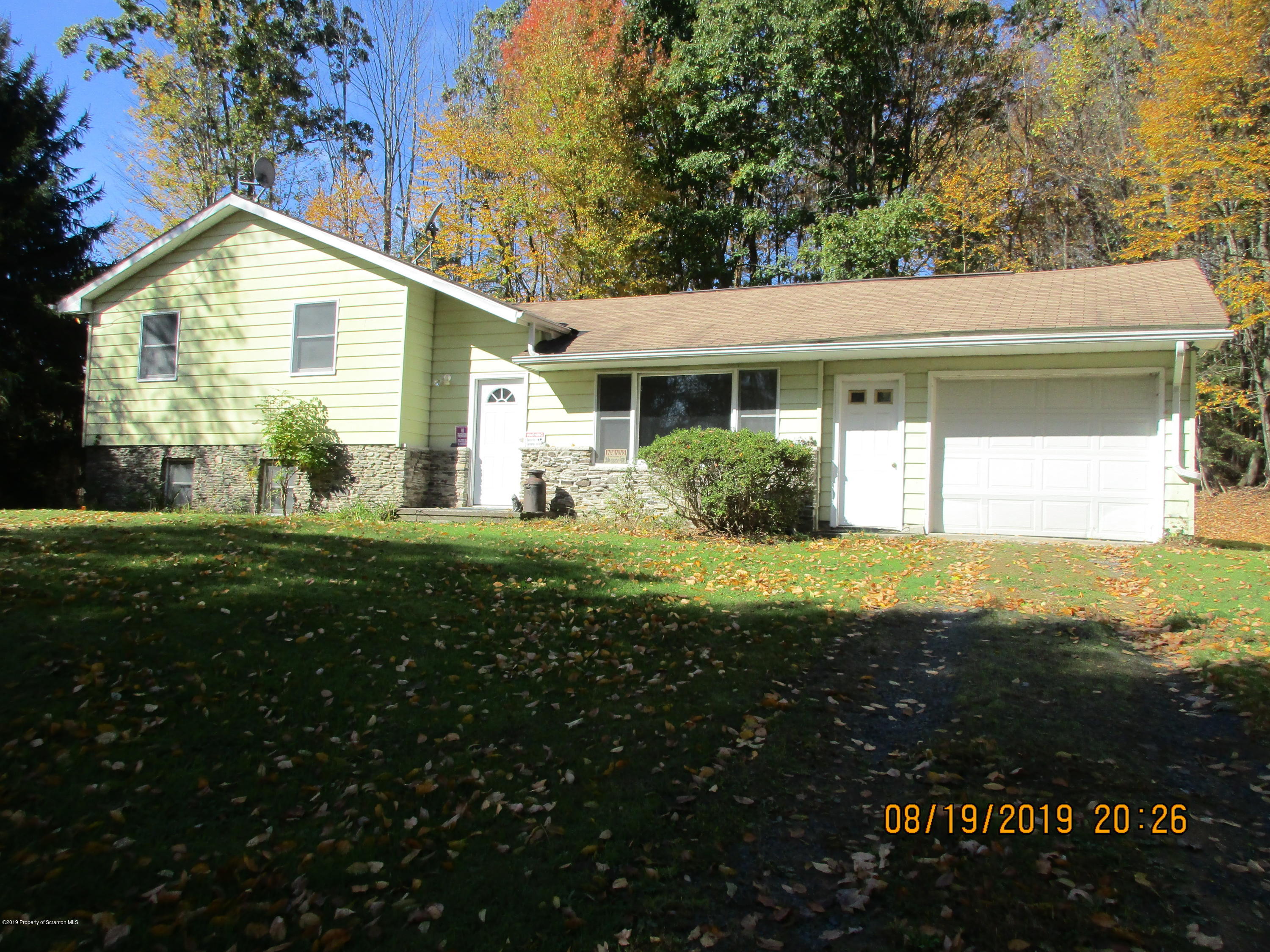 a front view of house with yard and green space
