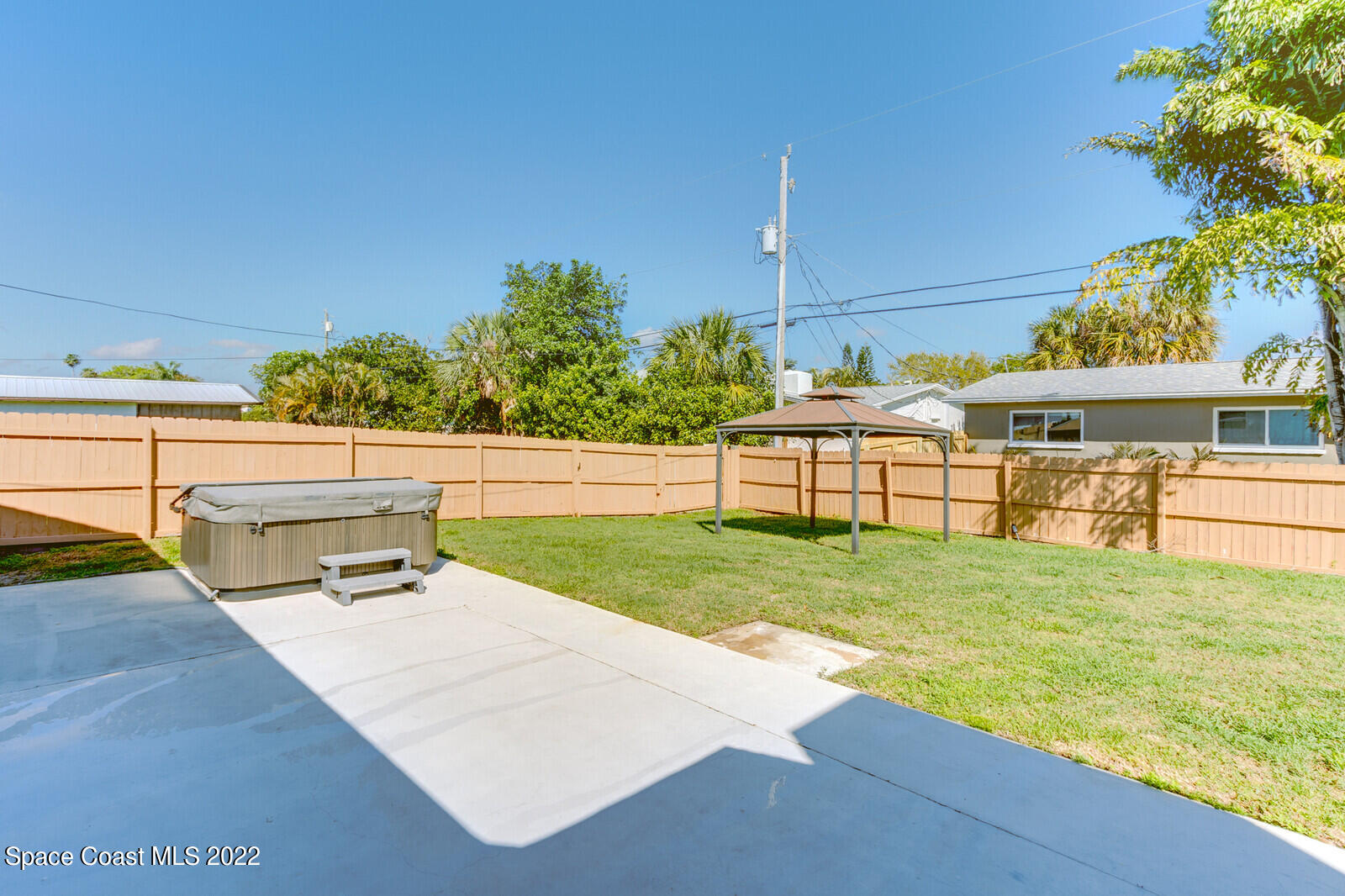 210 Sand Pine Road Indialantic, FL 32903 - Photo 27 of 45 a view of a swimming pool with a bench and trees