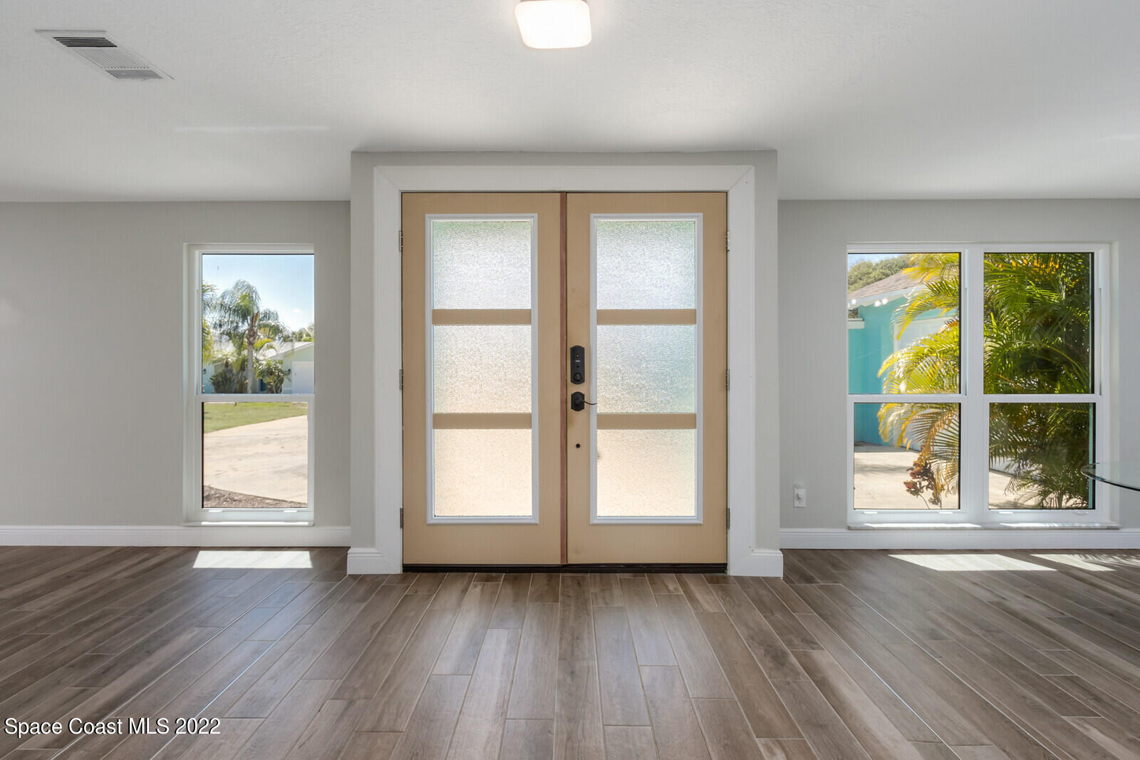 210 Sand Pine Road Indialantic, FL 32903 - Photo 7 of 45 a view of an empty room with wooden floor and a window