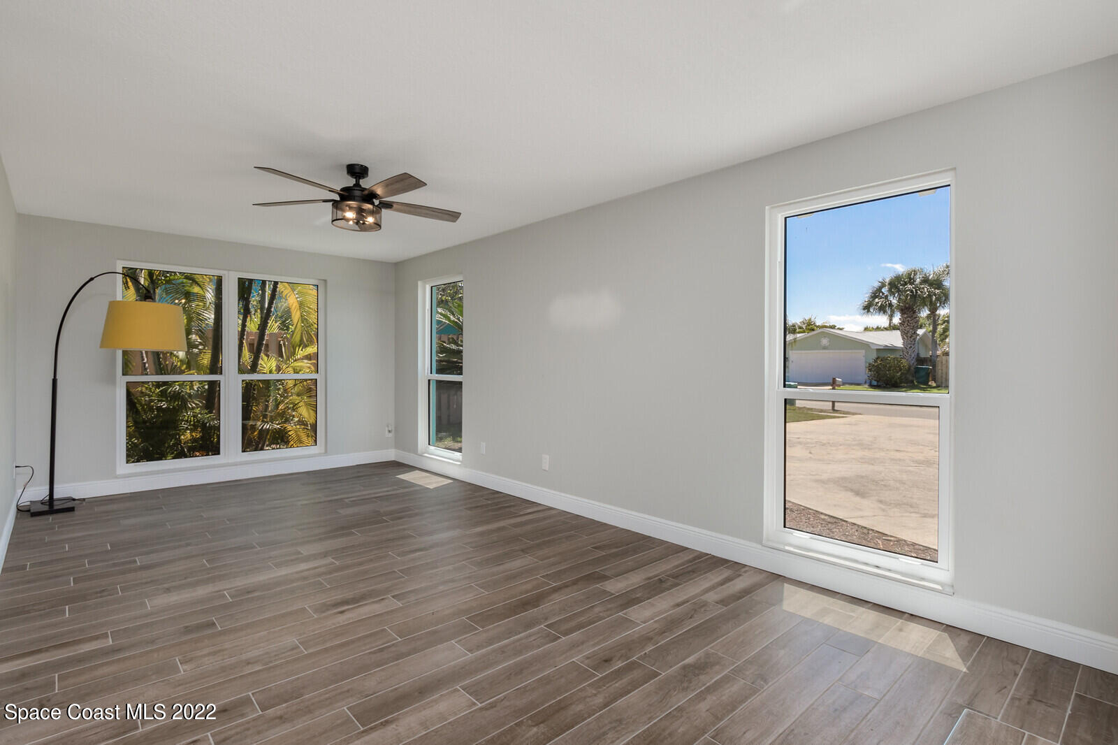 210 Sand Pine Road Indialantic, FL 32903 - Photo 8 of 45 a view of an empty room with a window and wooden floor