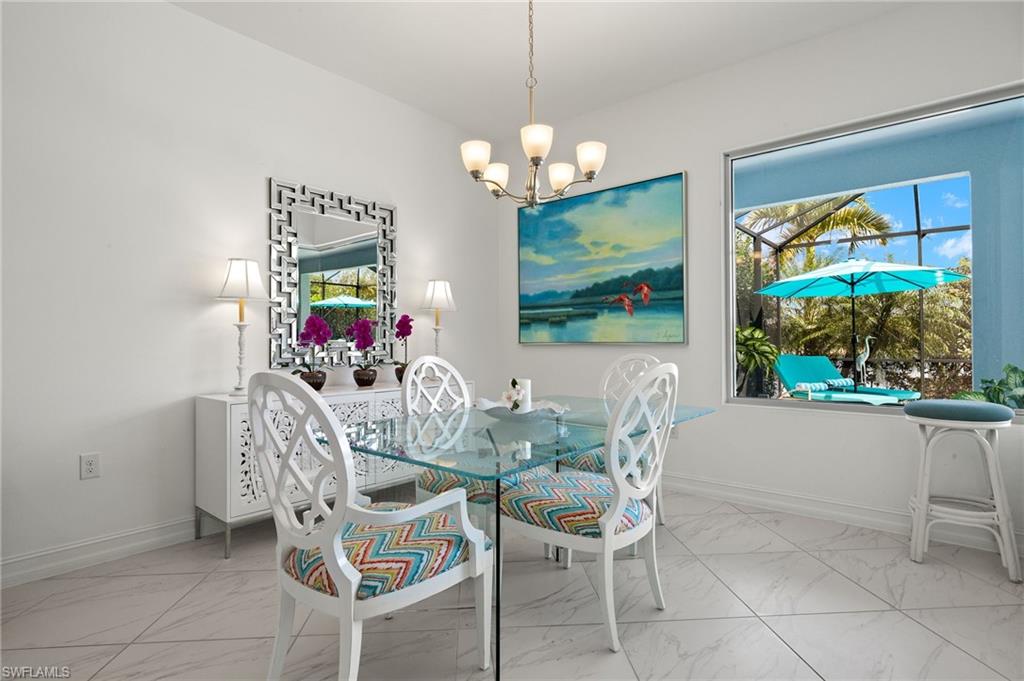 14809 Windward Lane Naples, FL 34114 - Photo 12 of 50 a dining room with furniture a large window and a chandelier