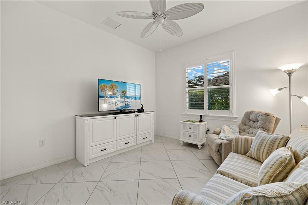 14809 Windward Lane Naples, FL 34114 - Photo 14 of 50 a living room with furniture and a flat screen tv