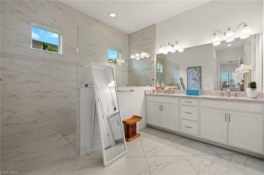 14809 Windward Lane Naples, FL 34114 - Photo 23 of 50 a bathroom with a sink a light fixture and a mirror