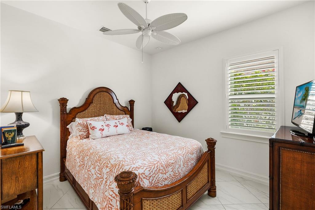 14809 Windward Lane Naples, FL 34114 - Photo 26 of 50 a bedroom with a bed and a flat tv screen on the dresser