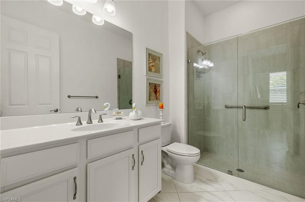 14809 Windward Lane Naples, FL 34114 - Photo 28 of 50 a bathroom with a double vanity sink toilet and shower