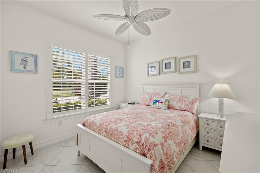 14809 Windward Lane Naples, FL 34114 - Photo 29 of 50 a bedroom with a bed and a chandelier