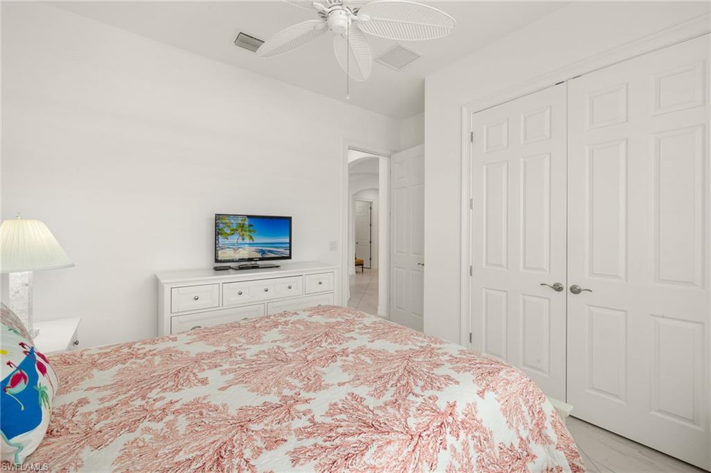 14809 Windward Lane Naples, FL 34114 - Photo 30 of 50 a bedroom with a bed and a flat tv screen on dresser