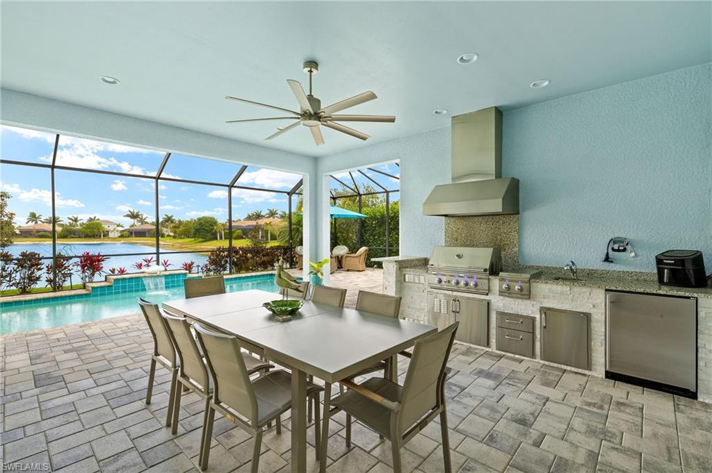 14809 Windward Lane Naples, FL 34114 - Photo 35 of 50 a view of a dining room and kitchen with a table chairs and a floor to ceiling window