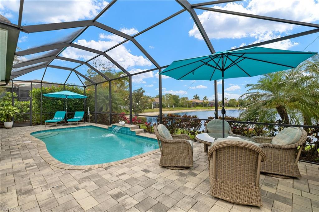 14809 Windward Lane Naples, FL 34114 - Photo 37 of 50 a view of a patio with a table and chairs under an umbrella