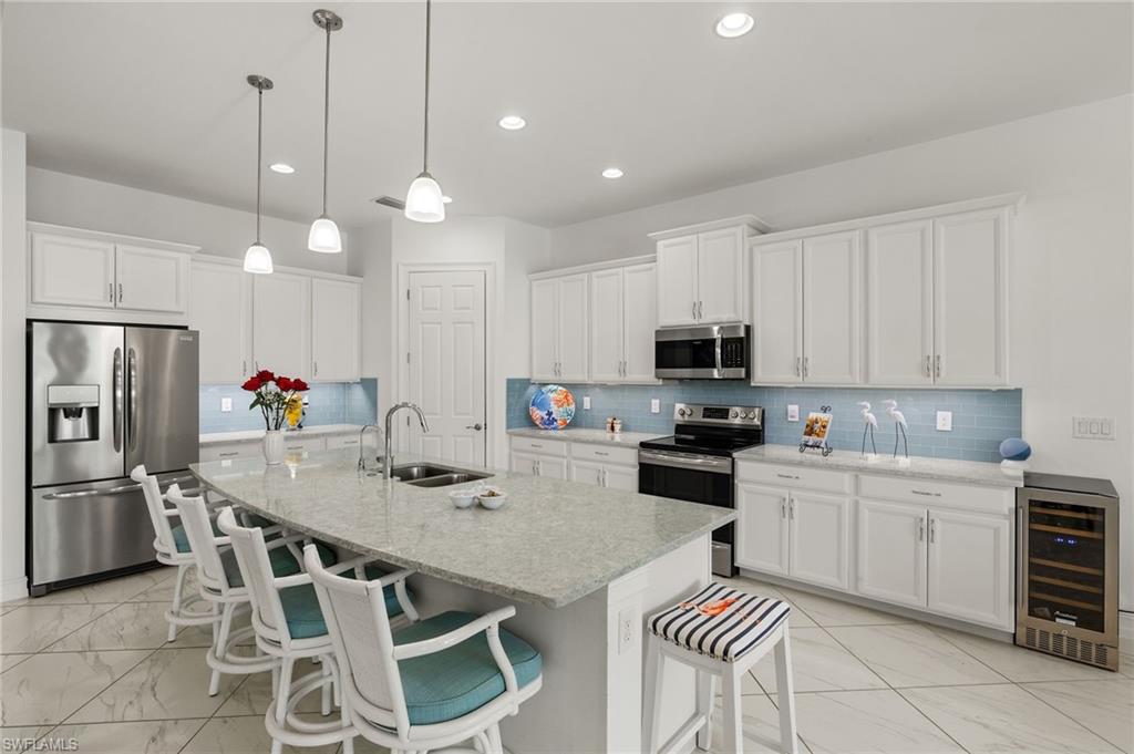 14809 Windward Lane Naples, FL 34114 - Photo 8 of 50 a kitchen with stainless steel appliances kitchen island granite countertop a sink and cabinets