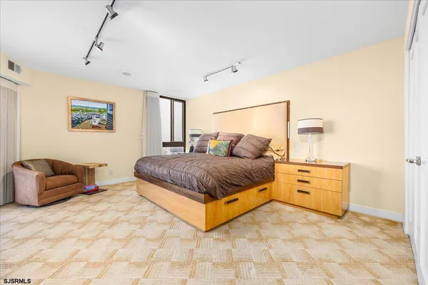 a spacious bedroom with a bed and cabinets