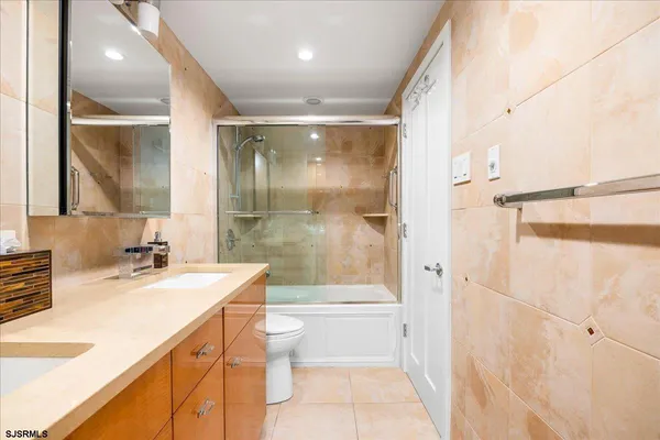 a bathroom with a sink a toilet a mirror and shower