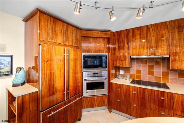 a kitchen with stainless steel appliances granite countertop a refrigerator and a stove top oven
