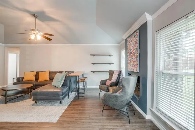 a living room with furniture wooden floor and a window