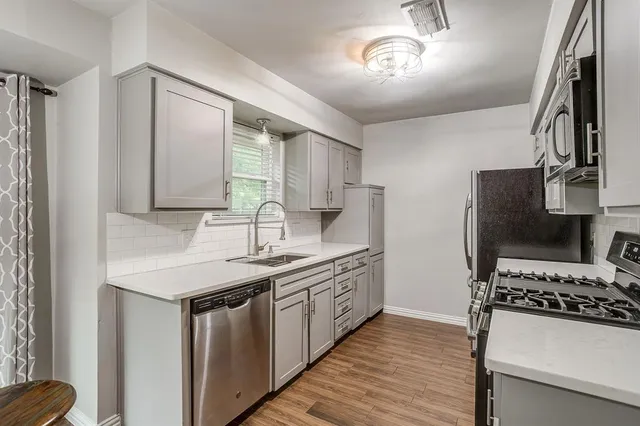 a kitchen with stainless steel appliances a sink stove and refrigerator