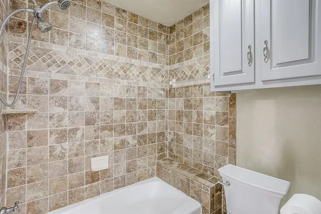 a bathroom with a toilet and a shower