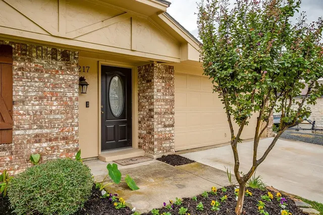 a front view of a house with a tree