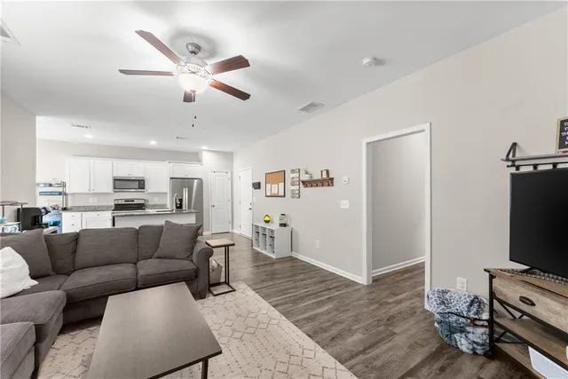 a living room with furniture and a flat screen tv with wooden floor