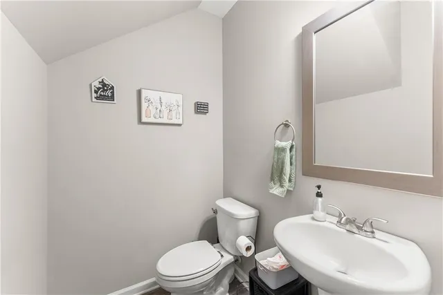 a bathroom with a toilet a sink and mirror