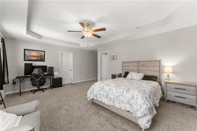 a bedroom with a bed couch and a ceiling fan