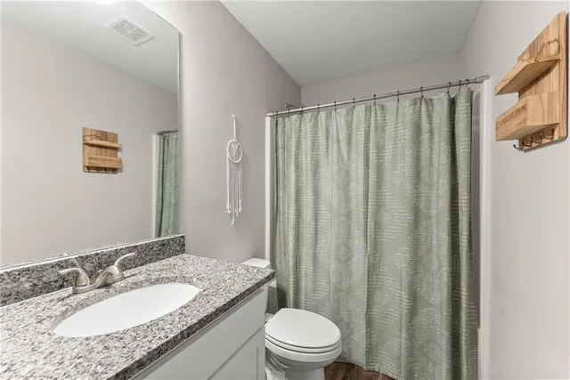 a bathroom with a granite countertop sink toilet and shower