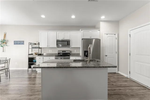 a kitchen with stainless steel appliances granite countertop a refrigerator a stove a sink a microwave a counter space and cabinets