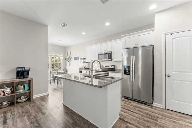 a kitchen with stainless steel appliances granite countertop a refrigerator and a sink