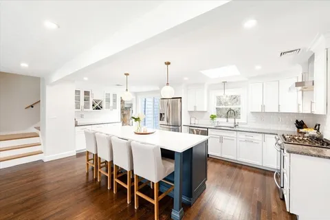 a kitchen with a dining table chairs stove refrigerator and cabinets