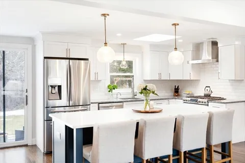 a kitchen with stainless steel appliances granite countertop a sink a stove and a refrigerator