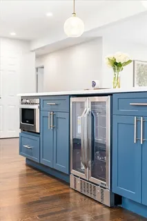 a view of a hallway with wooden floor and cabinet with a living room