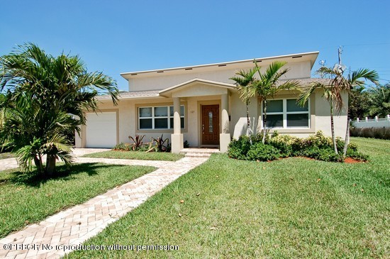 121 Gregory Road West Palm Beach, FL 33405 - Photo 1 of 8 a front view of a house with a yard and potted plants