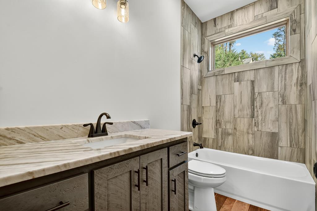 1204 Settler's Ridge Road Ellijay, GA 30540 - Photo 61 of 62 a bathroom with a sink a toilet and shower